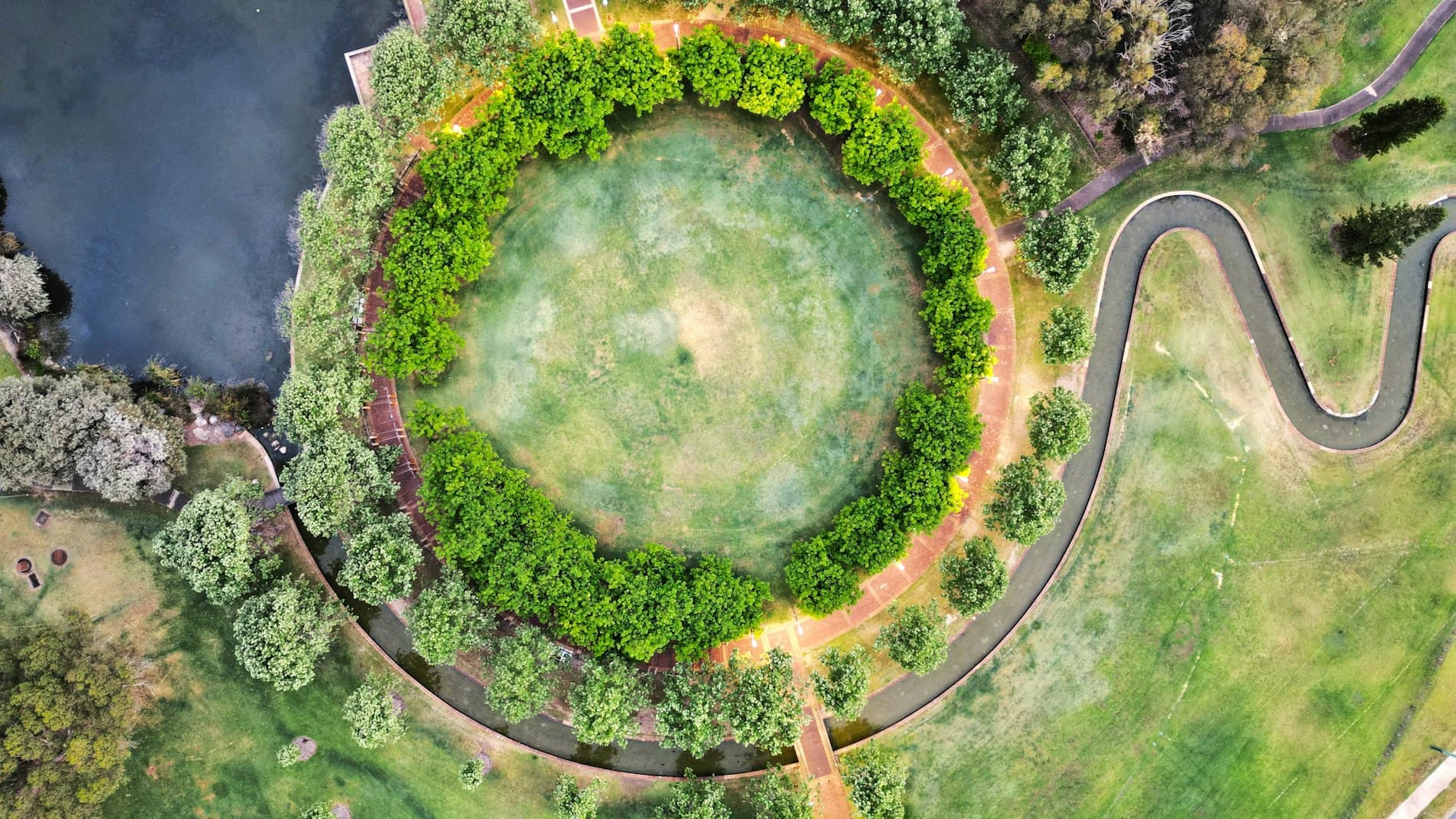 Aerial view of a circular park with a river running through it