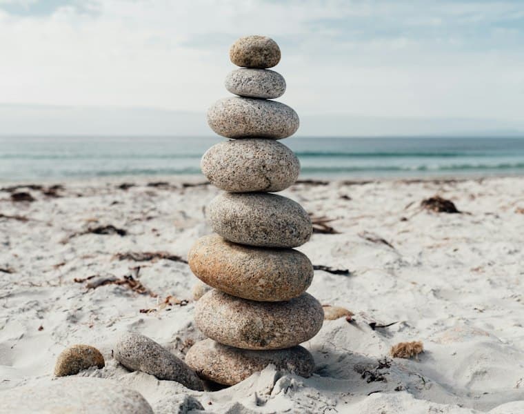 A stack of smooth stones balanced on a shoreline